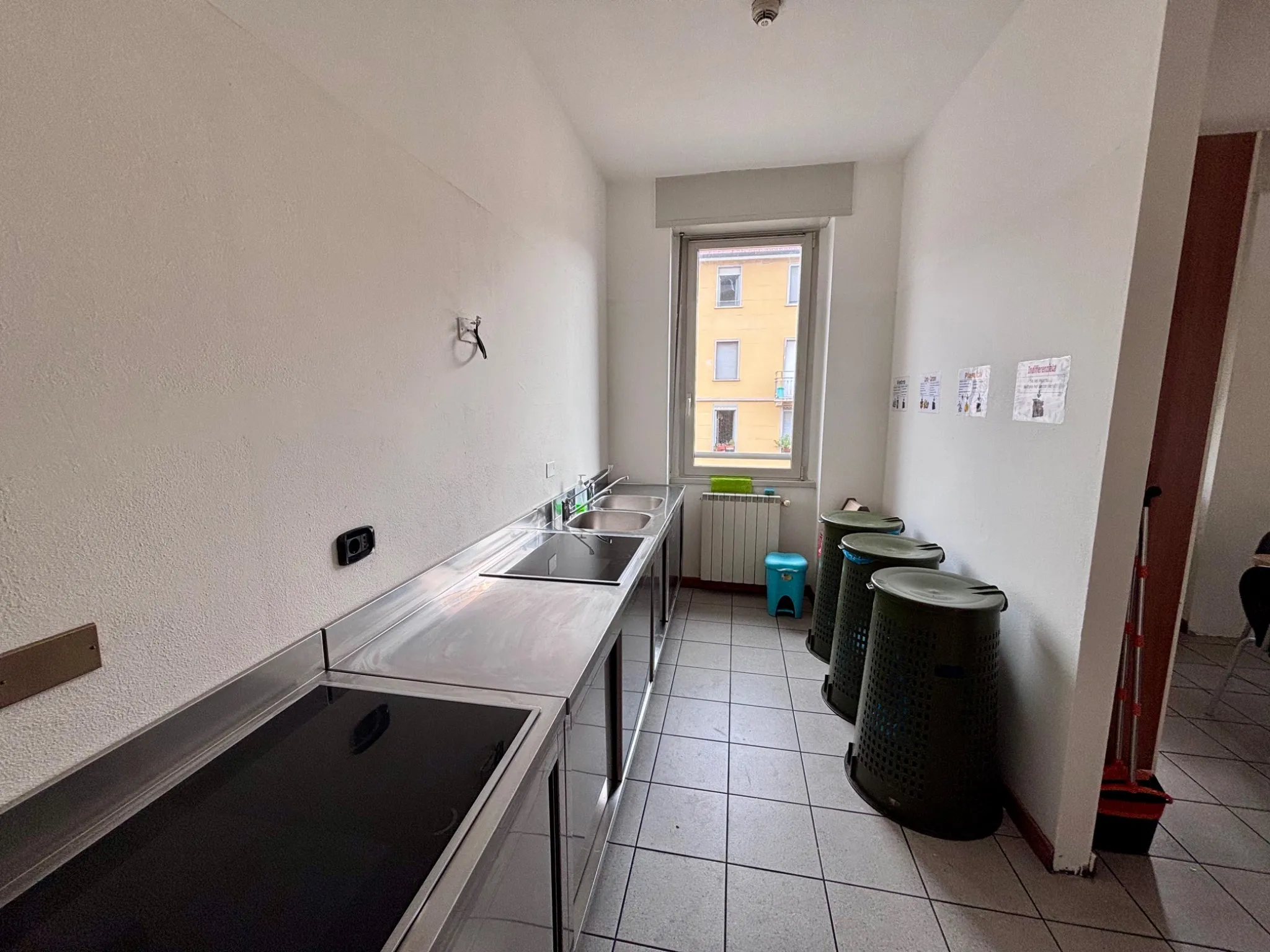 Student kitchen cooking area with induction hobs and recycling bins