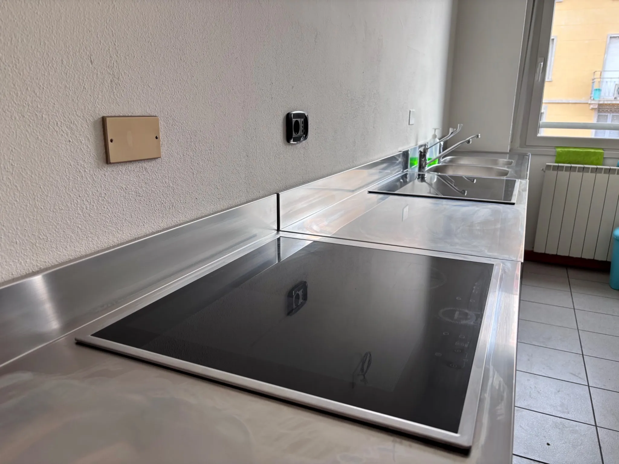 Induction hob with stainless steel sink in the student kitchen at Pensionato Bertoni
